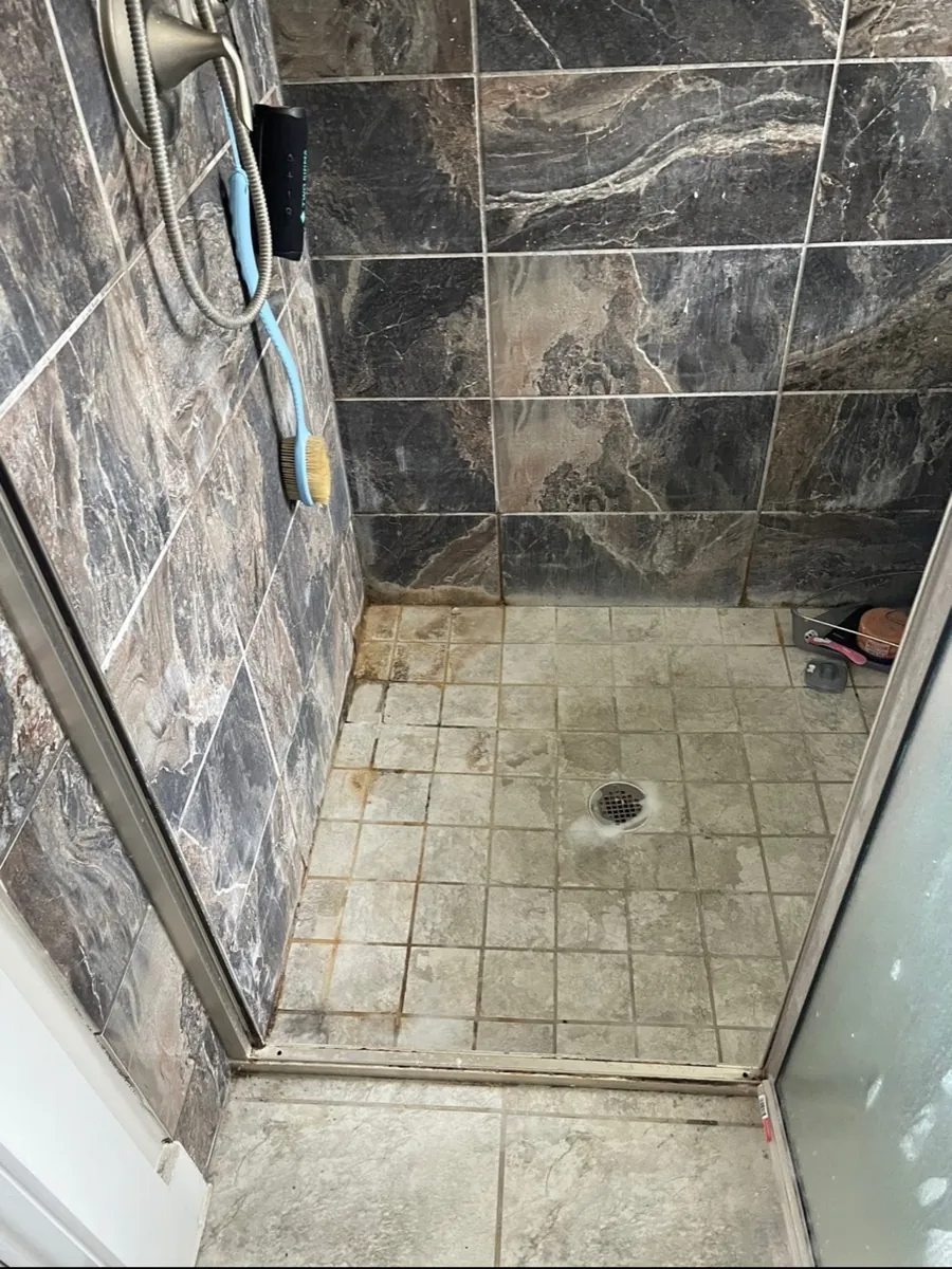 Shower walls with soap scum before cleaning